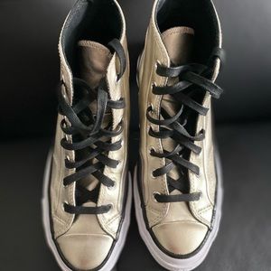 Converse gold high tops.